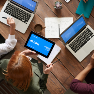 Personas trabajando con laptops y una tablet, expuestas a la luz de las pantallas